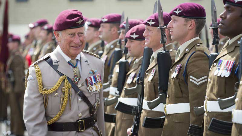 Príncipe Charles, vestindo uma túnica militar, enquanto visitava o regimento de páraquedas britânico.